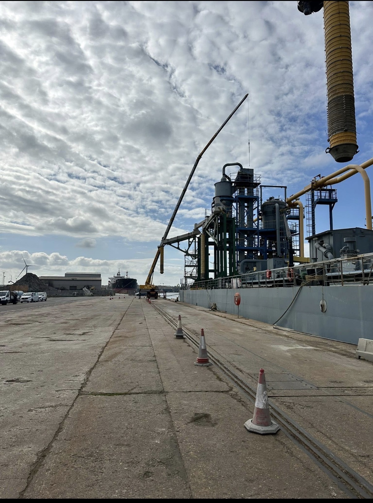Mobile crane working alongside a docked vessel