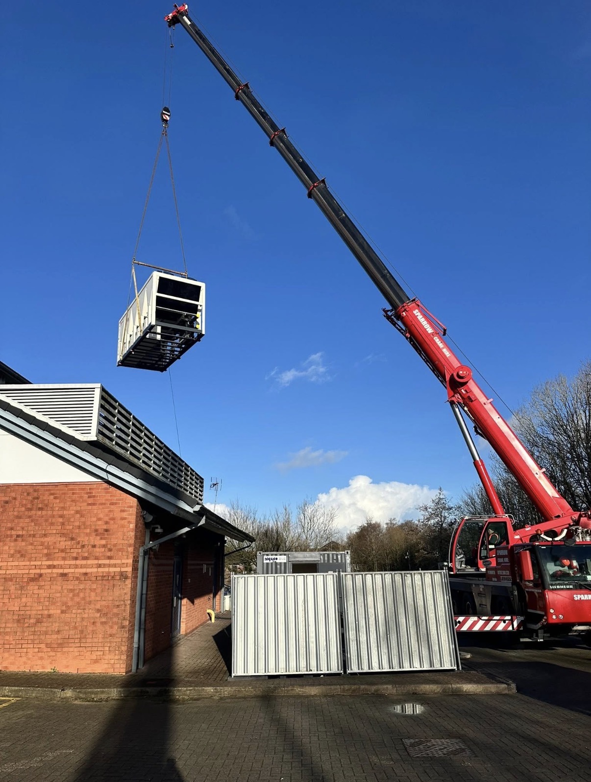 Sparrow crane lifting an AC unit onto a rooftop