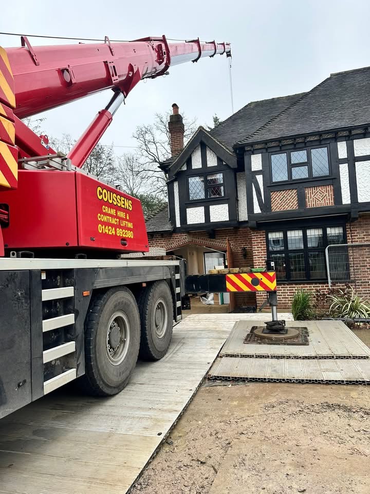 Coussens crane rigged in front of a Tudor-style residence